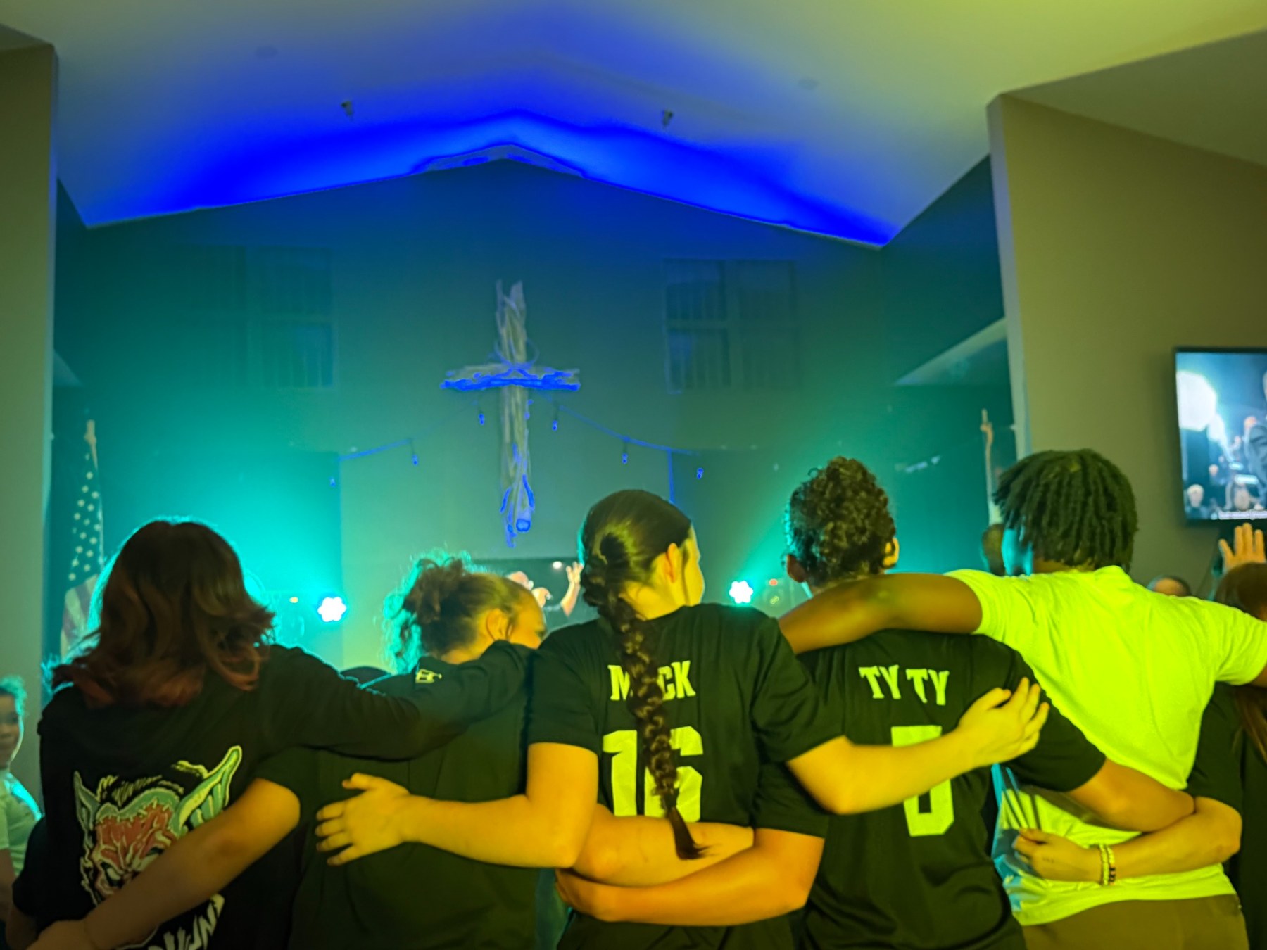 Students worshiping together with arms around each other